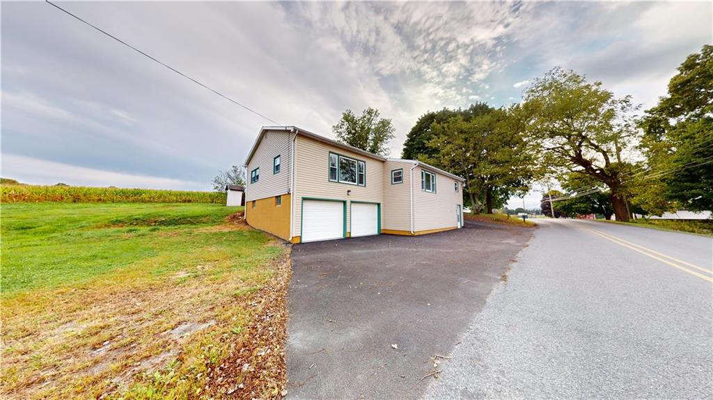 a view of a house with a yard and garage