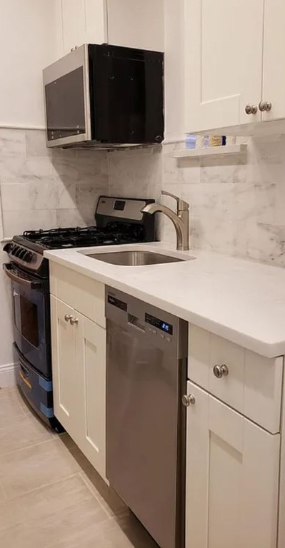 a kitchen with stainless steel appliances granite countertop a sink and a stove