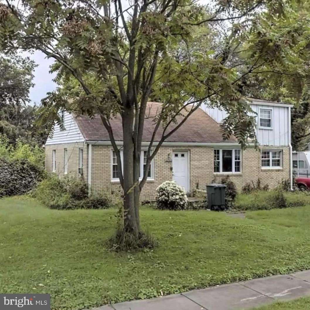 a front view of a house with a garden and trees