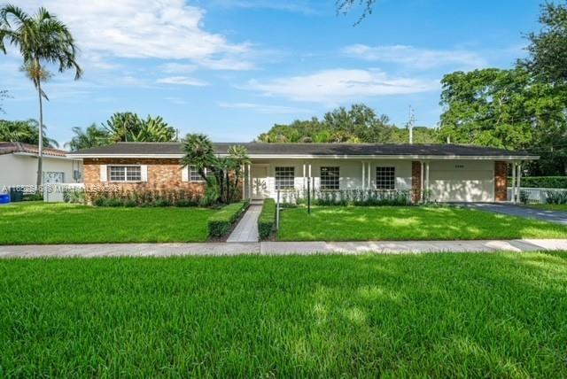 a view of house with a big yard and potted plants