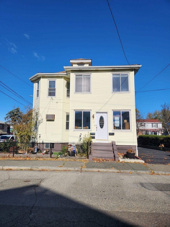 a view of a white building with a yard