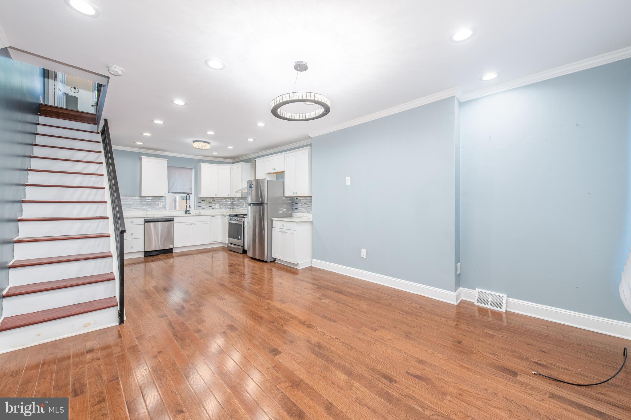 a view of kitchen with refrigerator cabinets and wooden floor