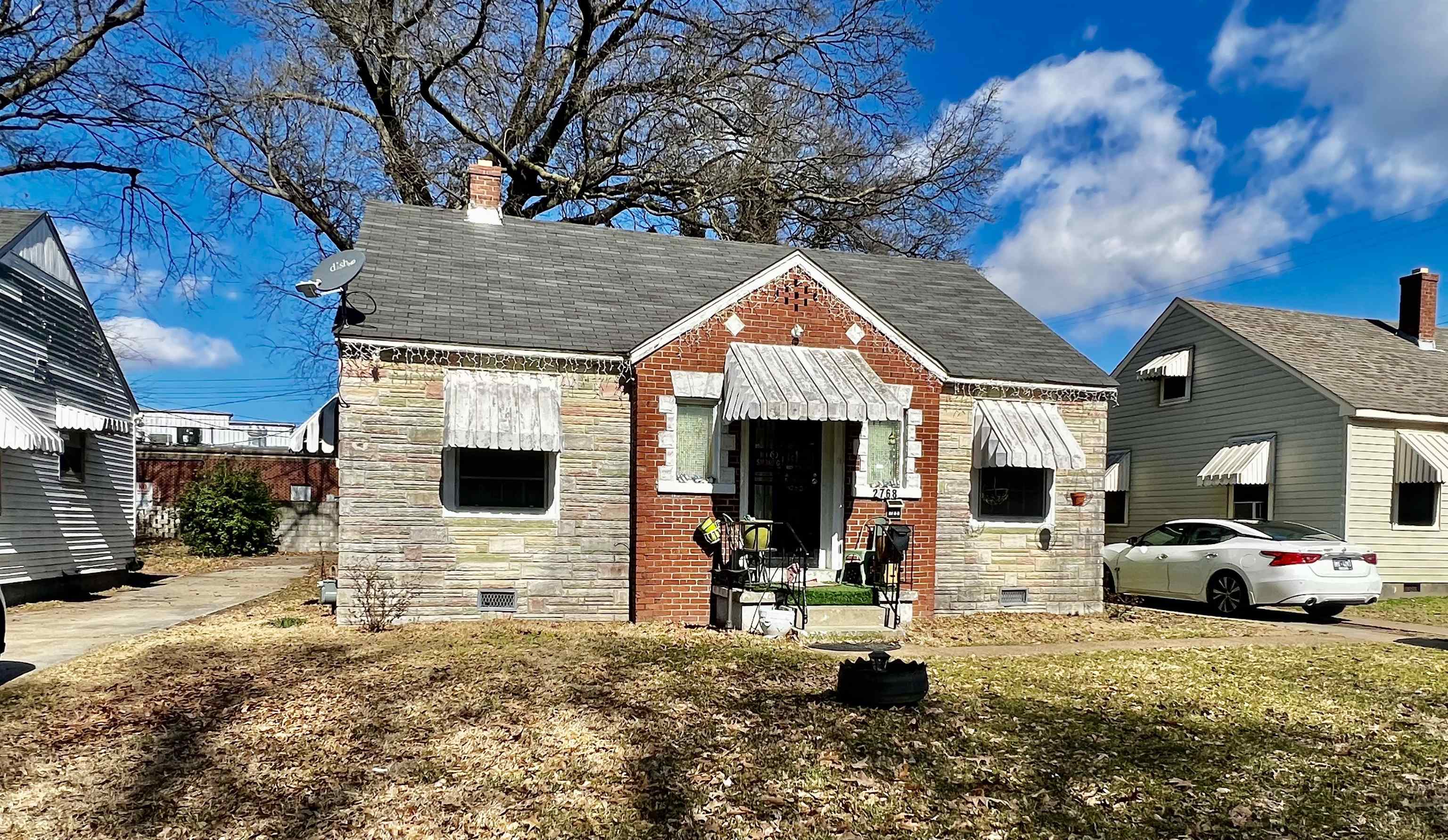 a front view of a house with cars parked