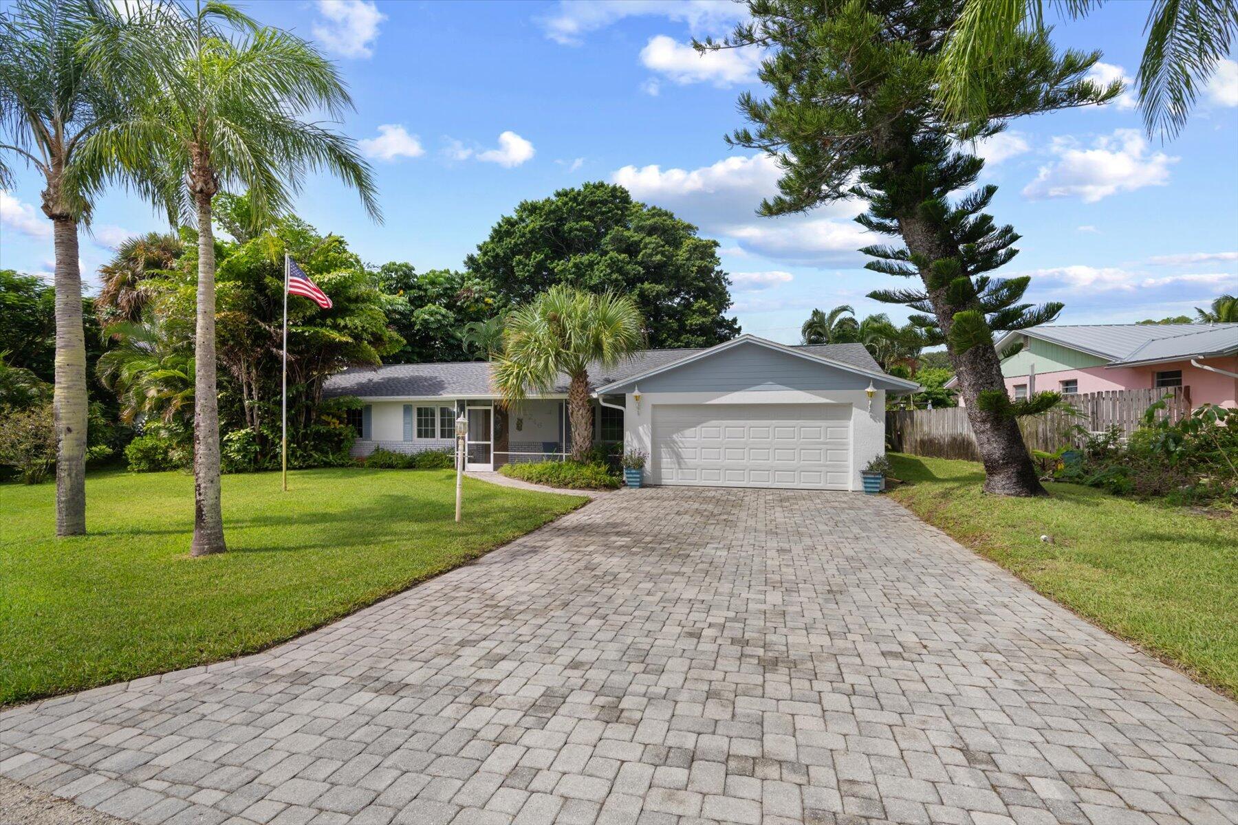 a front view of a house with a yard and trees