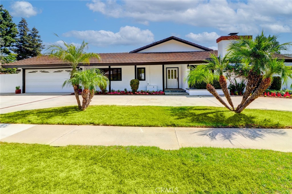 a front view of a house with a yard and potted plants