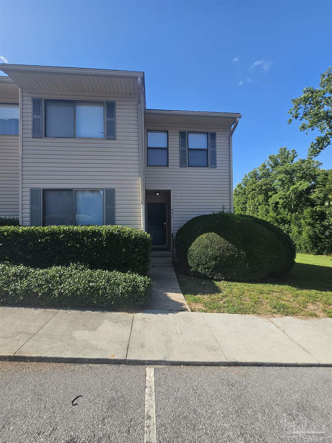 a view of a house with a yard and potted plants