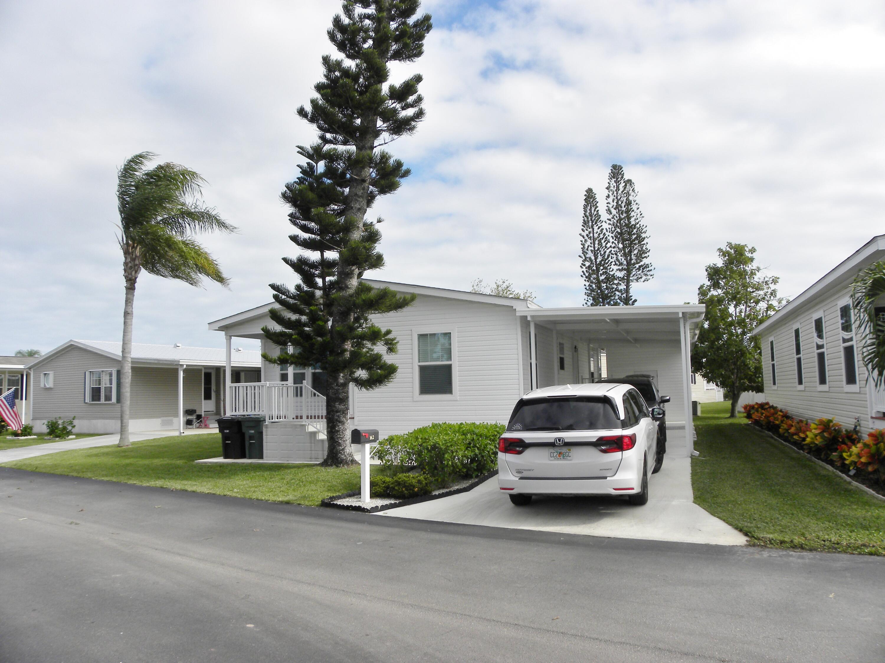 a car parked in front of a house and a small yard