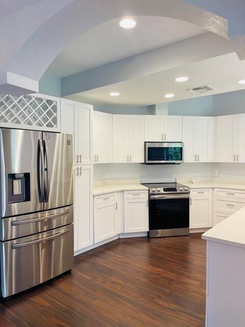 a kitchen with granite countertop a refrigerator and a stove top oven