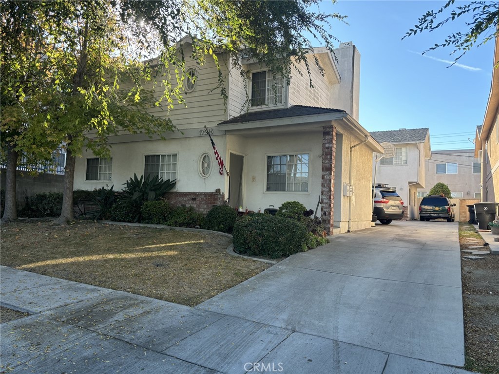 a front view of a house with yard and trees around