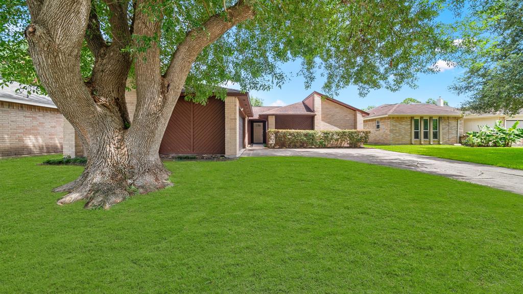 a front view of a house with a yard and trees