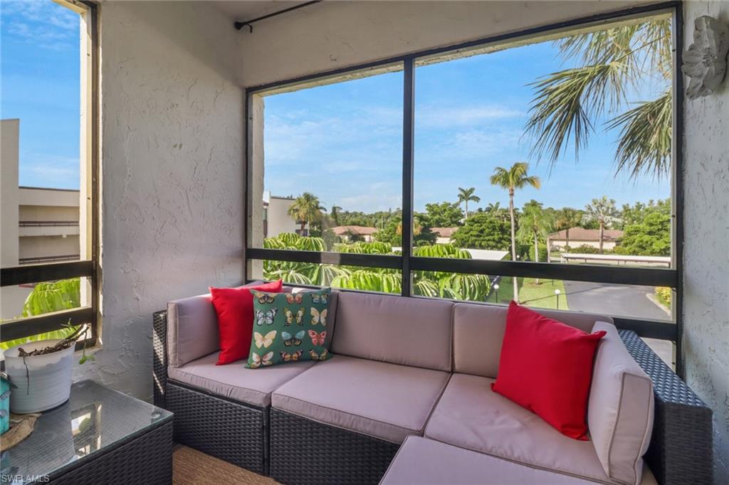 a living room with patio furniture and a potted plant