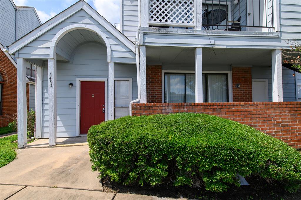 a view of a house with a small yard plants and large tree