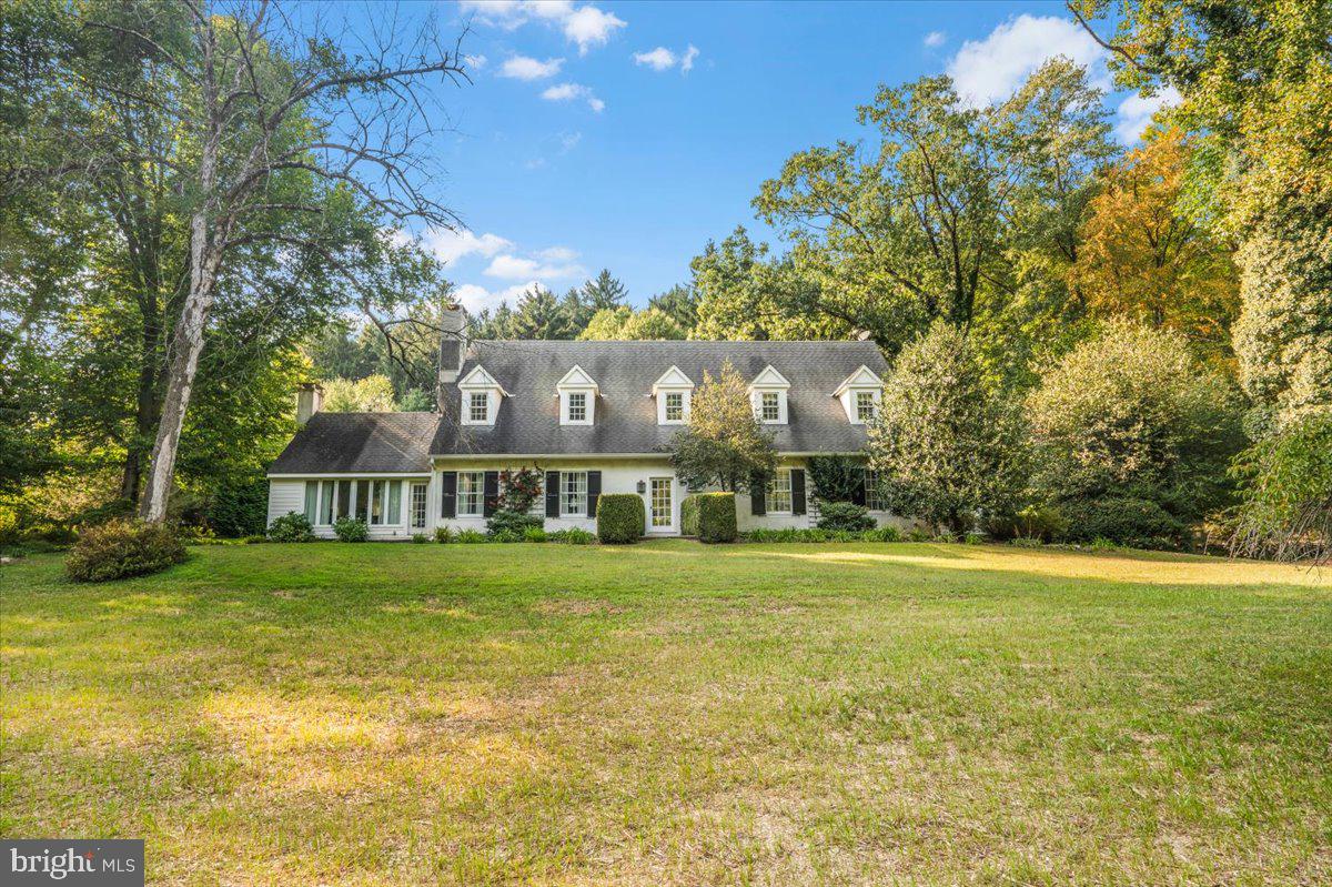 a view of a house next to a big yard with large trees