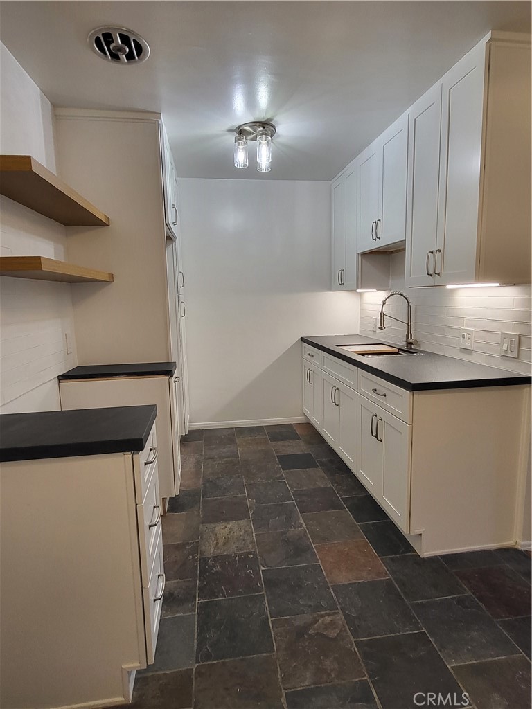 a kitchen with a sink a stove and cabinets