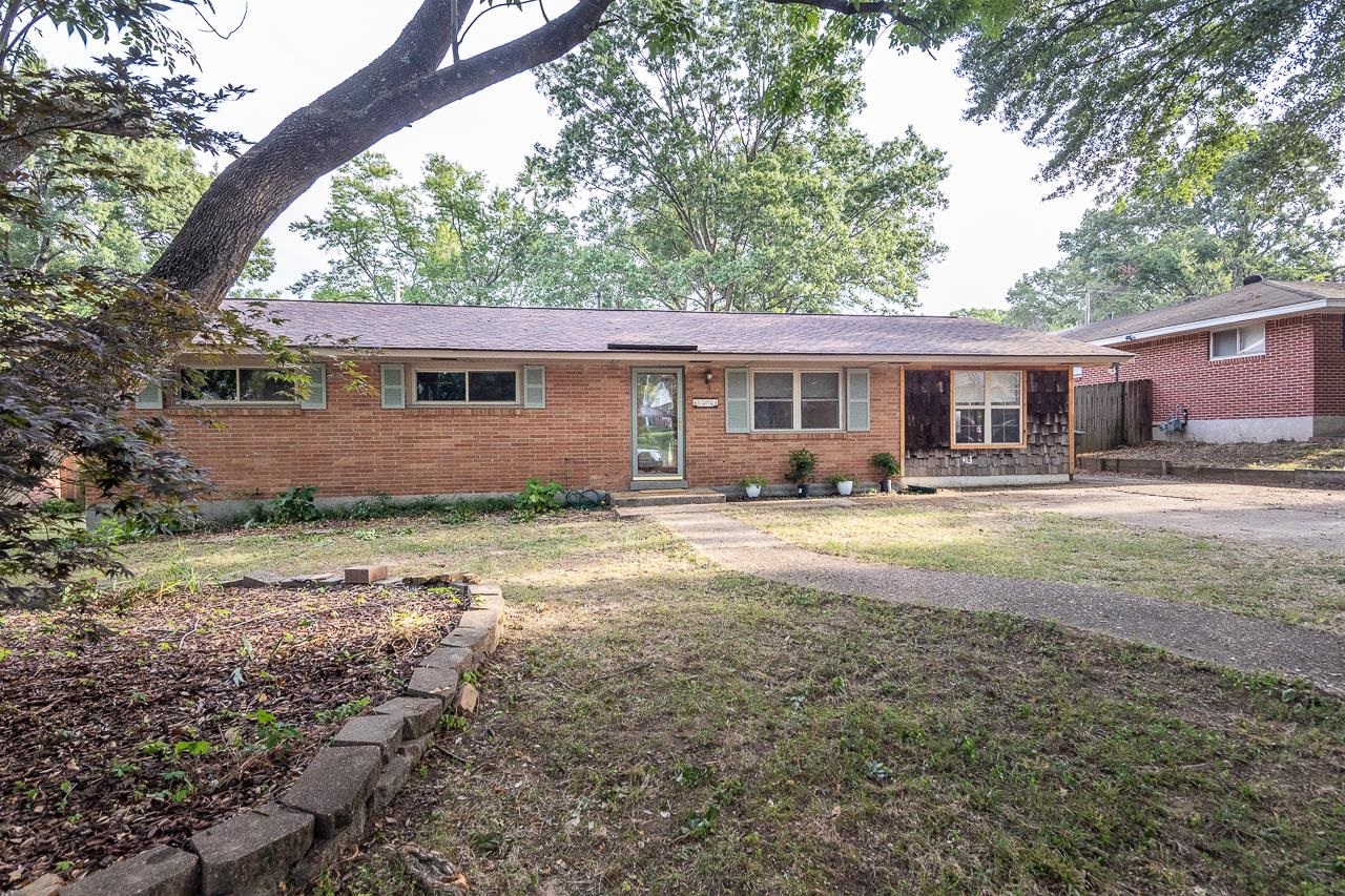 a front view of house with yard and trees around