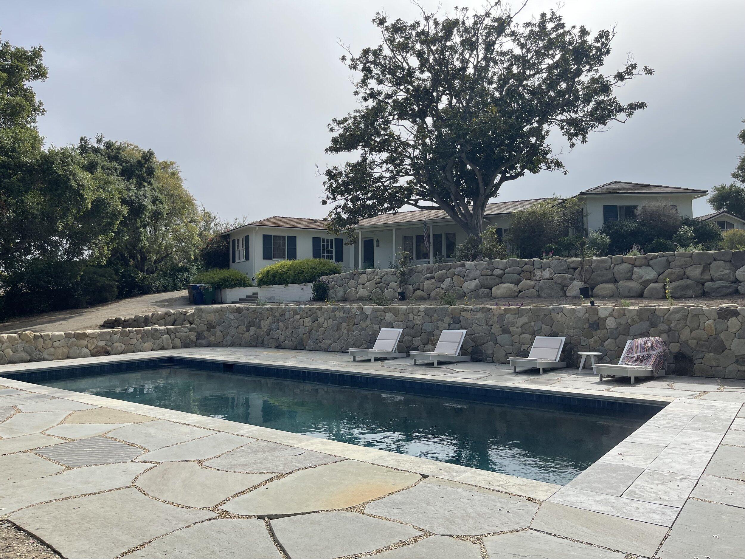 a view of house with swimming pool and yard with green space