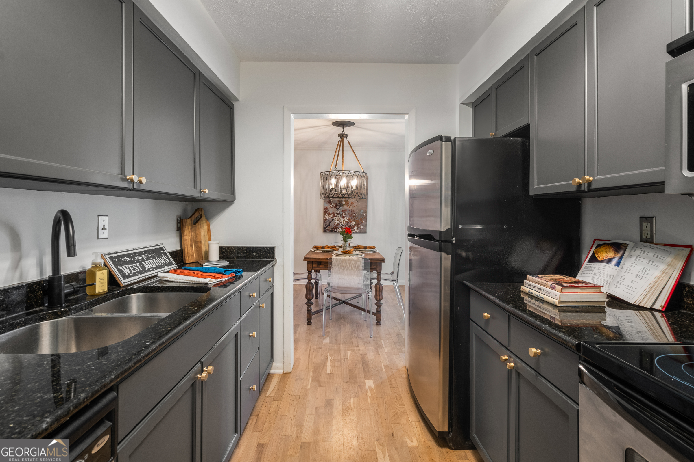 a kitchen with granite countertop a sink stove and refrigerator