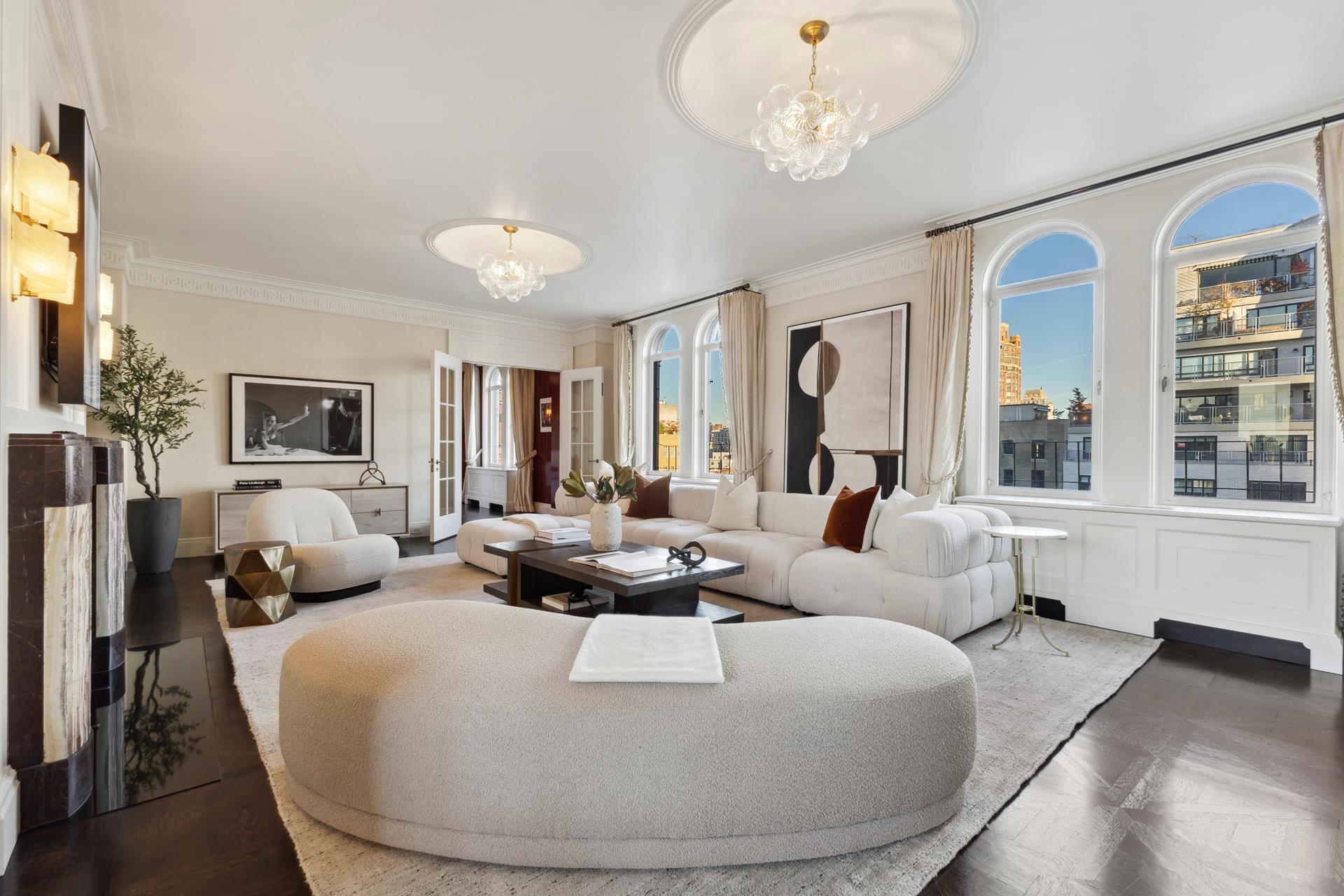 a living room with furniture chandelier and a large window