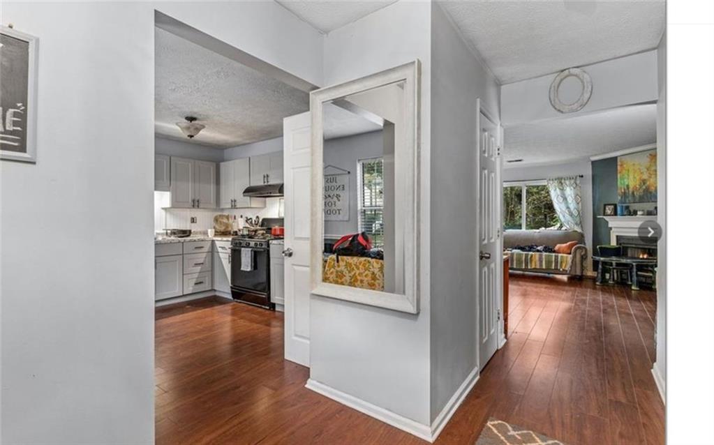 a living room with stainless steel appliances kitchen island wooden floor and view kitchen