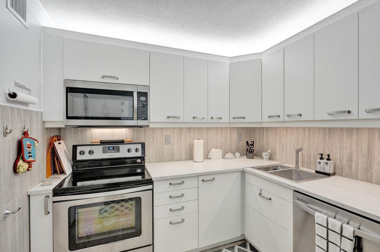 a kitchen with appliances a sink and cabinets