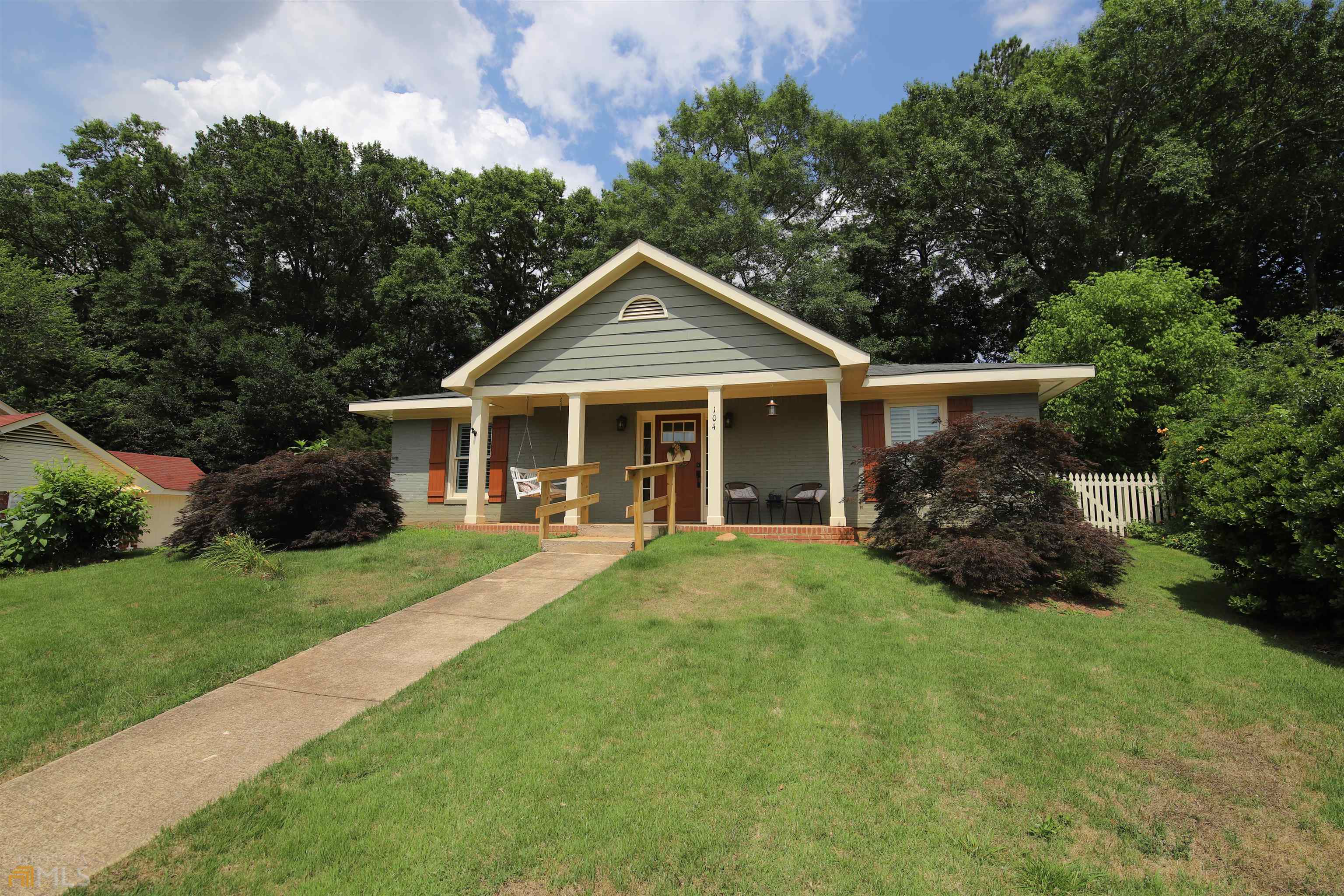 a front view of a house with a garden