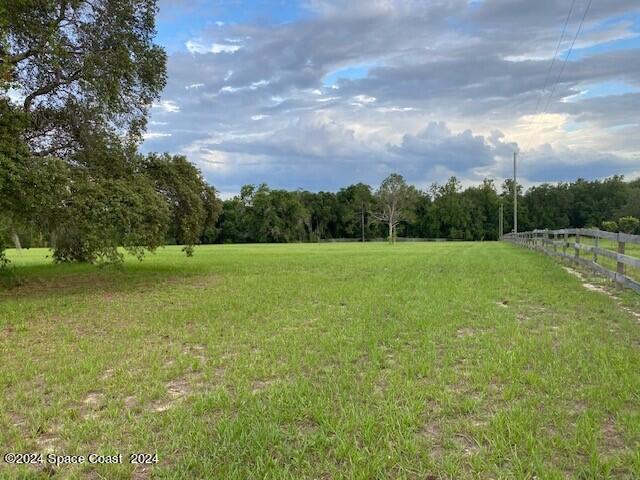 a view of a field with an trees in the background