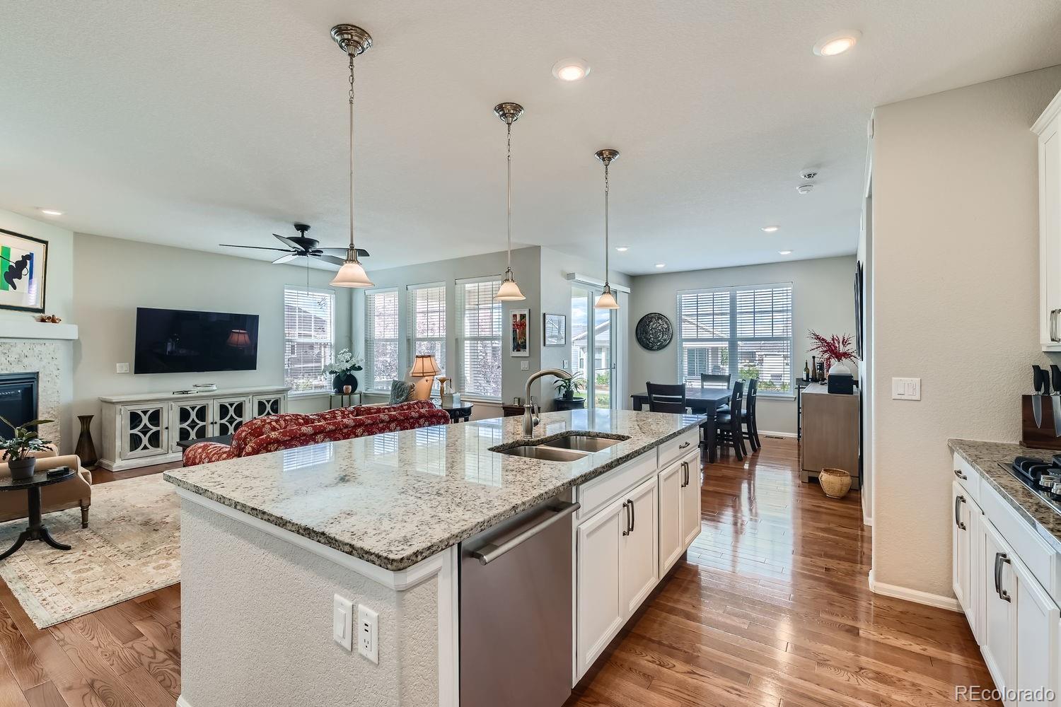 a kitchen with stainless steel appliances granite countertop a sink and a wooden floor