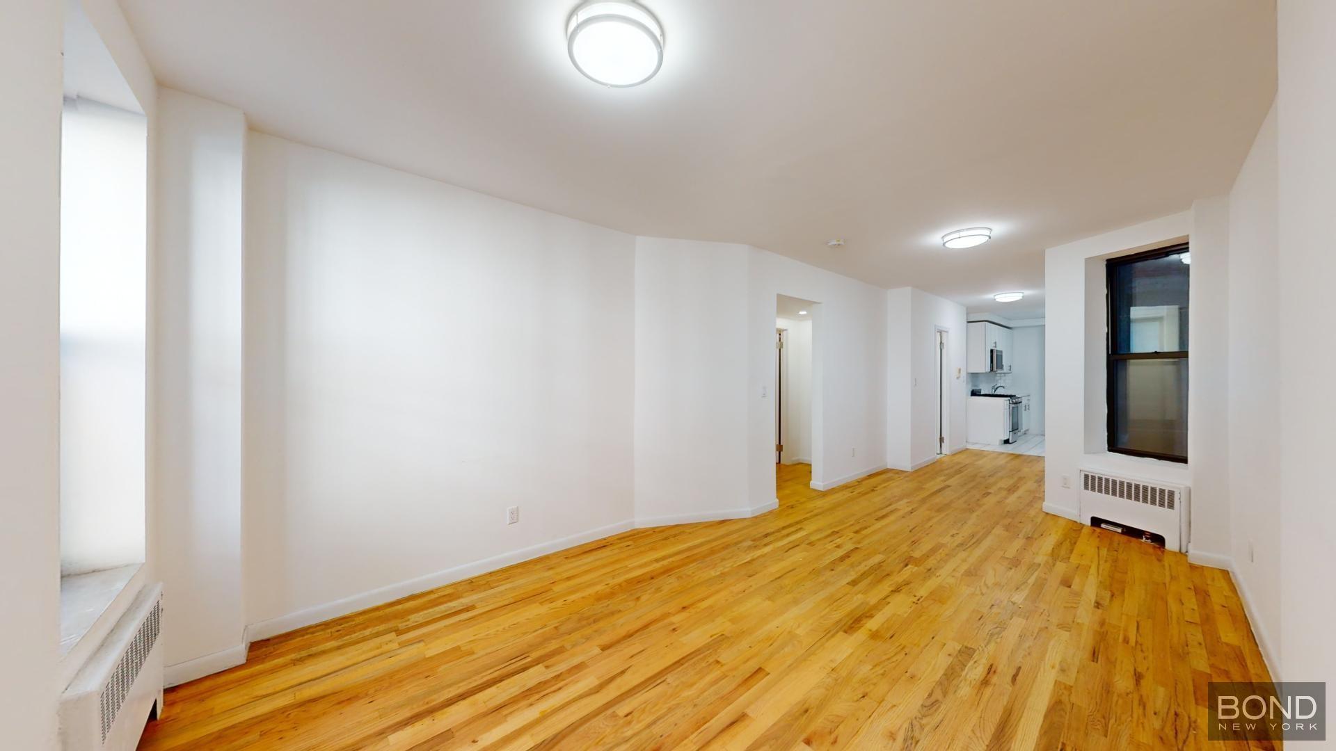 a big room with wooden floor and a bathroom