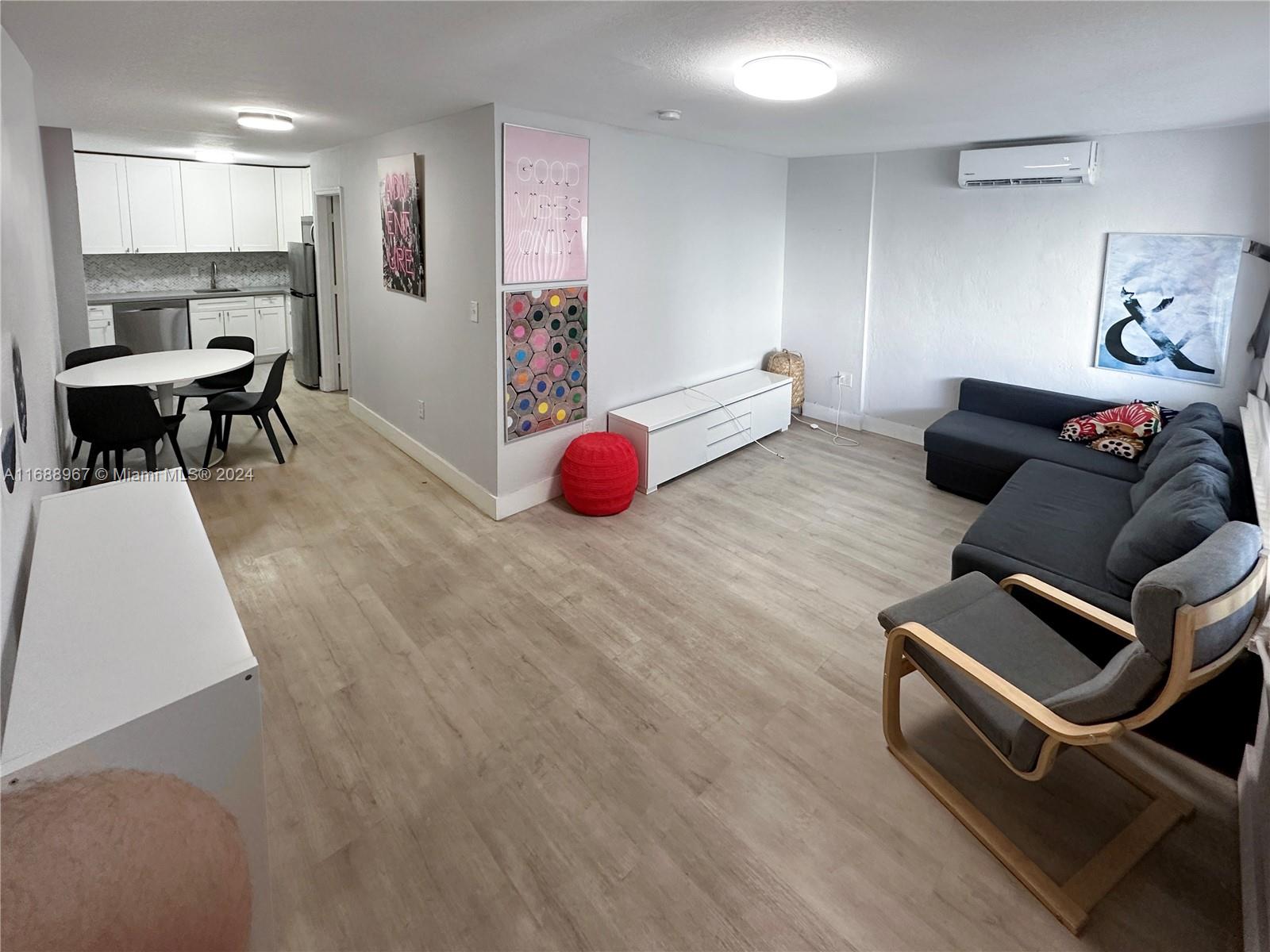 a living room with furniture and kitchen view