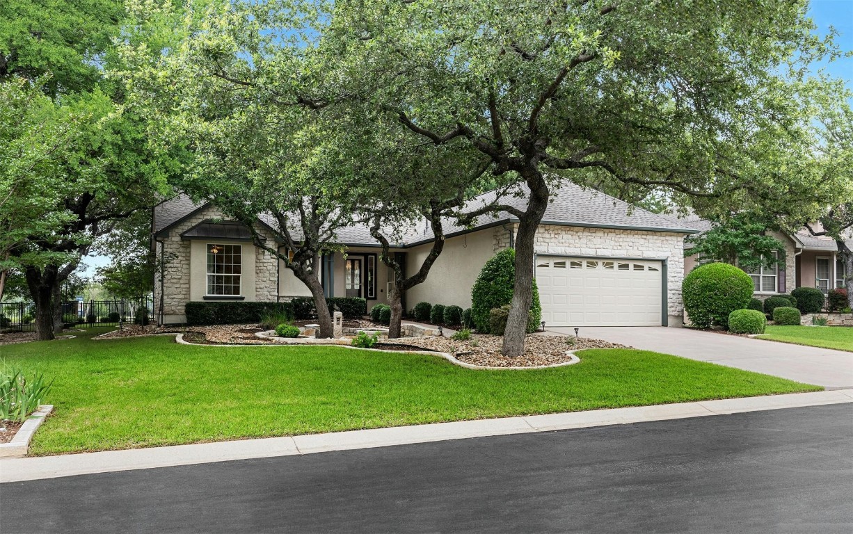 The front and backyard, both professionally landscaped in May 2024, feature stunning oak trees and xeriscape elements that provide a welcoming and low-maintenance curb appeal