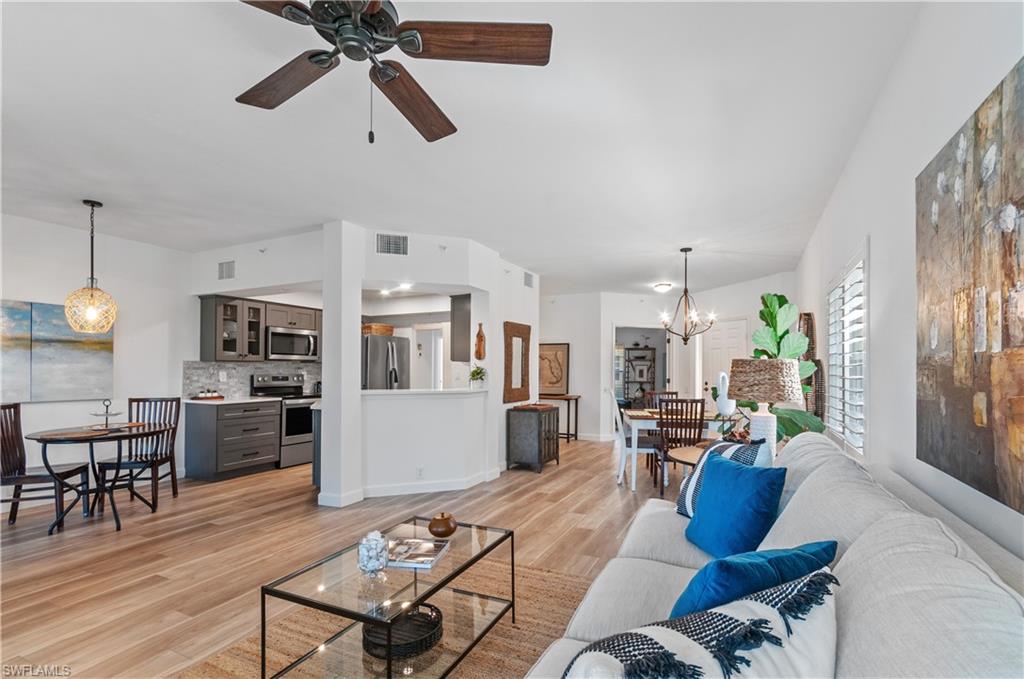 a living room with furniture kitchen view and a refrigerator