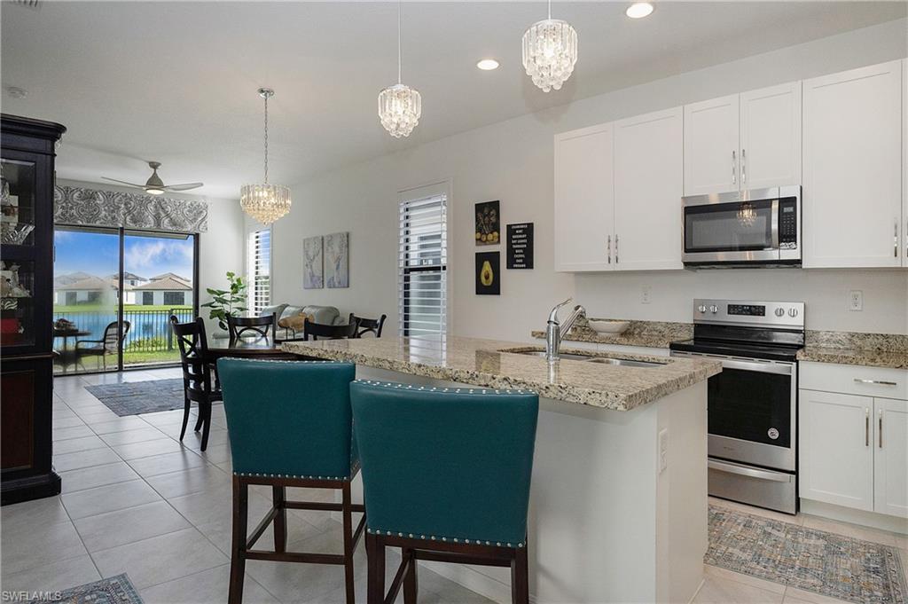 a kitchen with kitchen island granite countertop a sink cabinets and stainless steel appliances