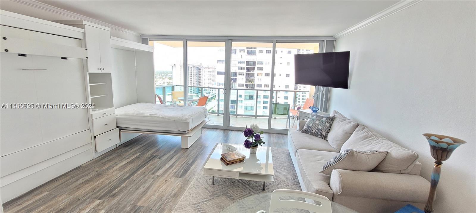 a living room with furniture and a floor to ceiling window