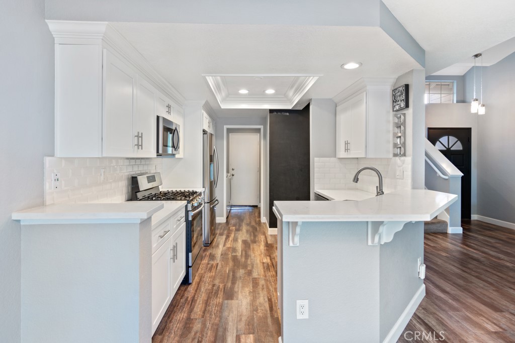 a kitchen with stainless steel appliances a sink stove and cabinets