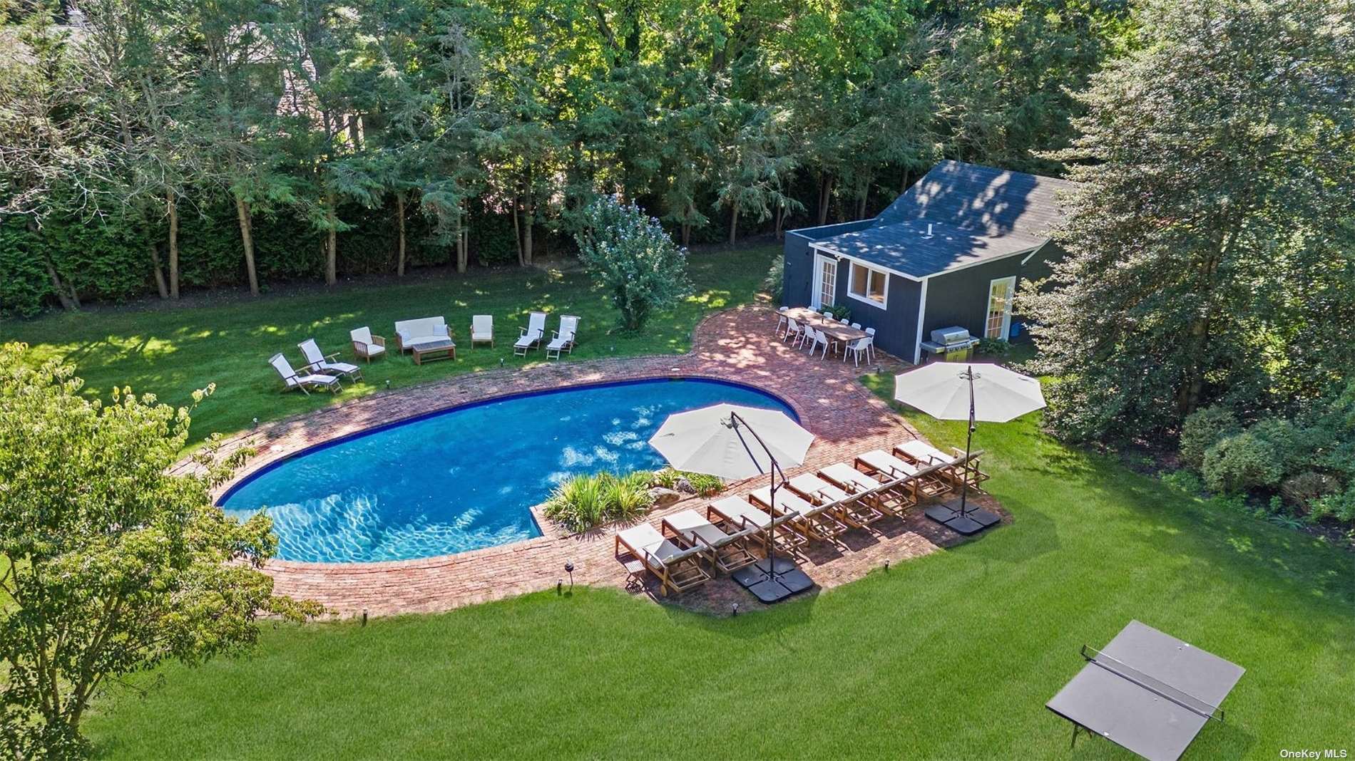 a view of a wooden table and chairs in backyard