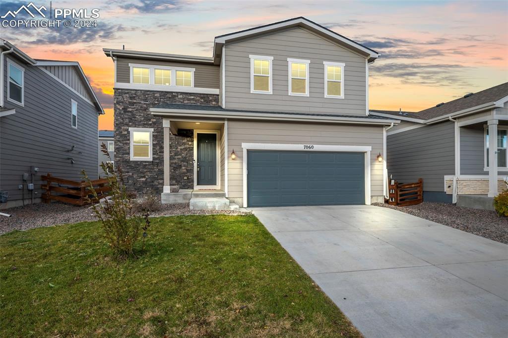 View of front of home featuring a garage and a yard