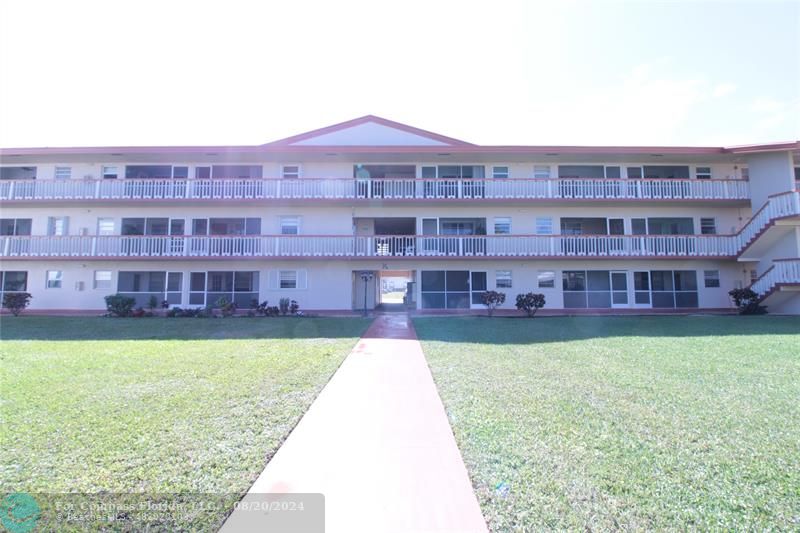 a view of a large building with a big yard and large trees