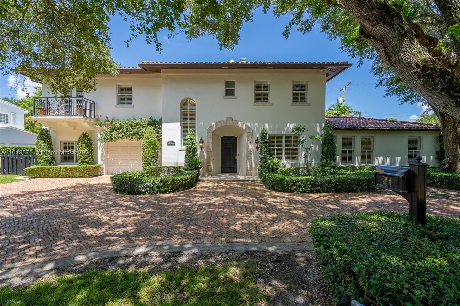 a front view of a house with yard and green space