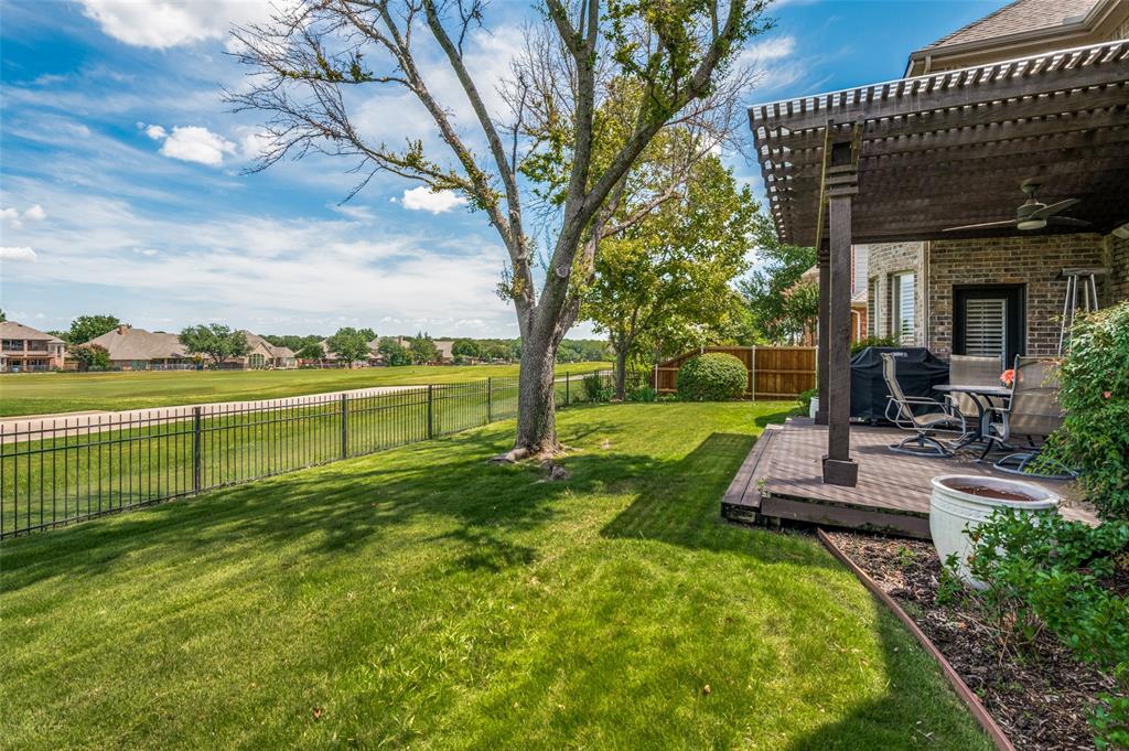 a view of a house with a big yard and a large tree