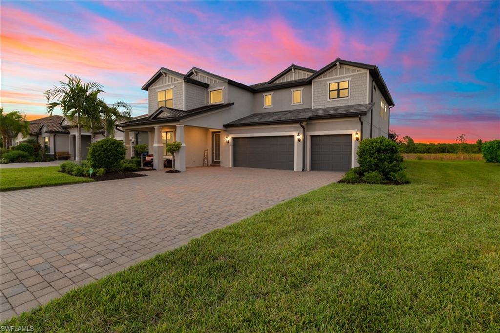 a view of a big house with a big yard and large trees