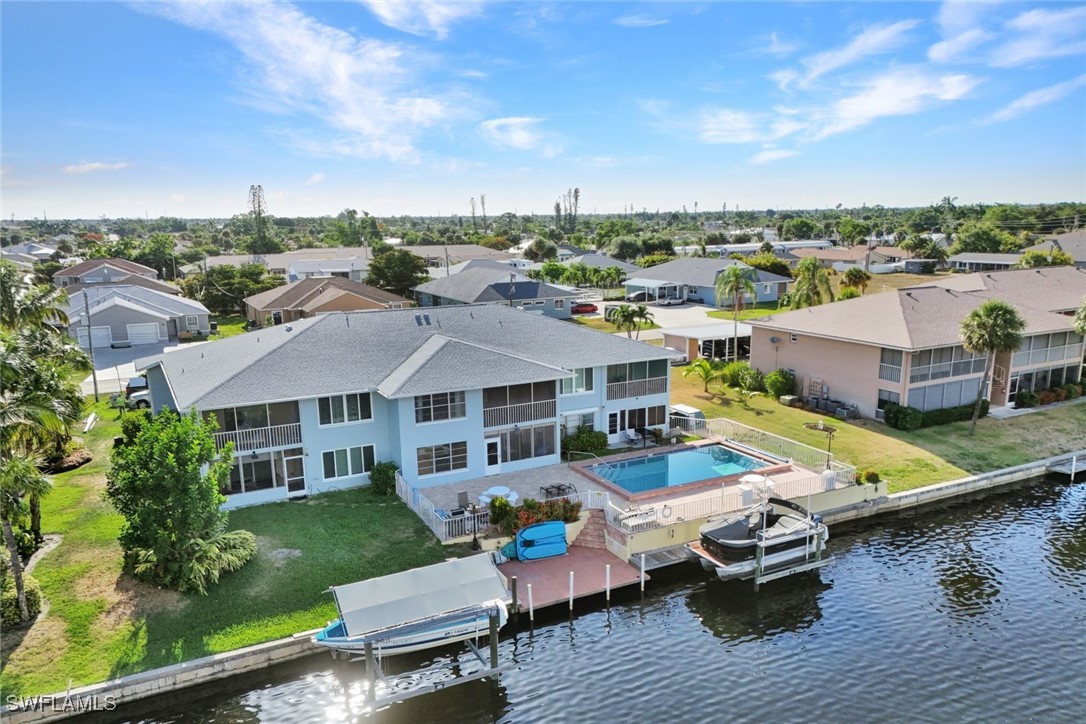 an aerial view of a house with swimming pool and outdoor seating