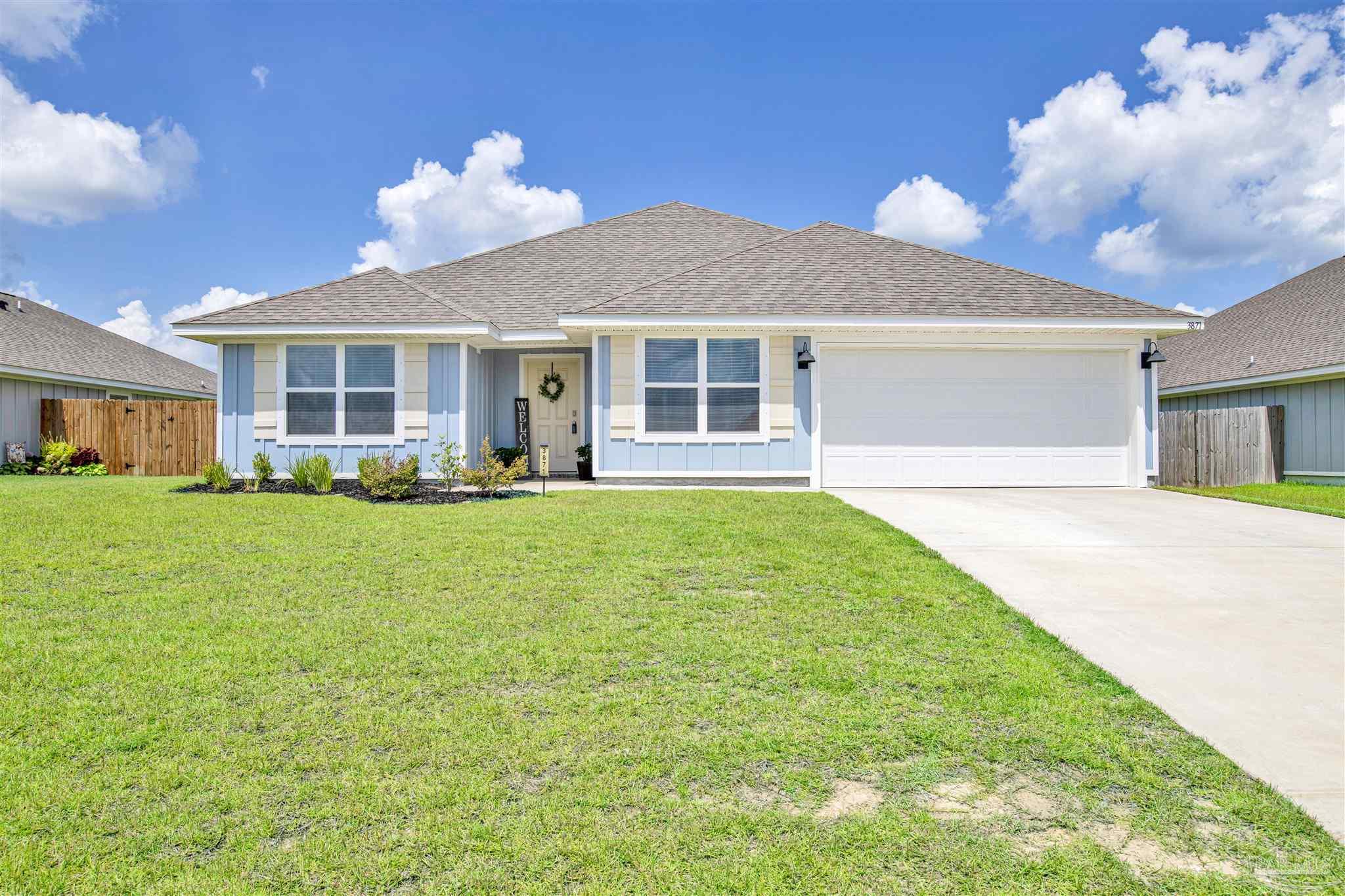 a front view of a house with a garden and yard