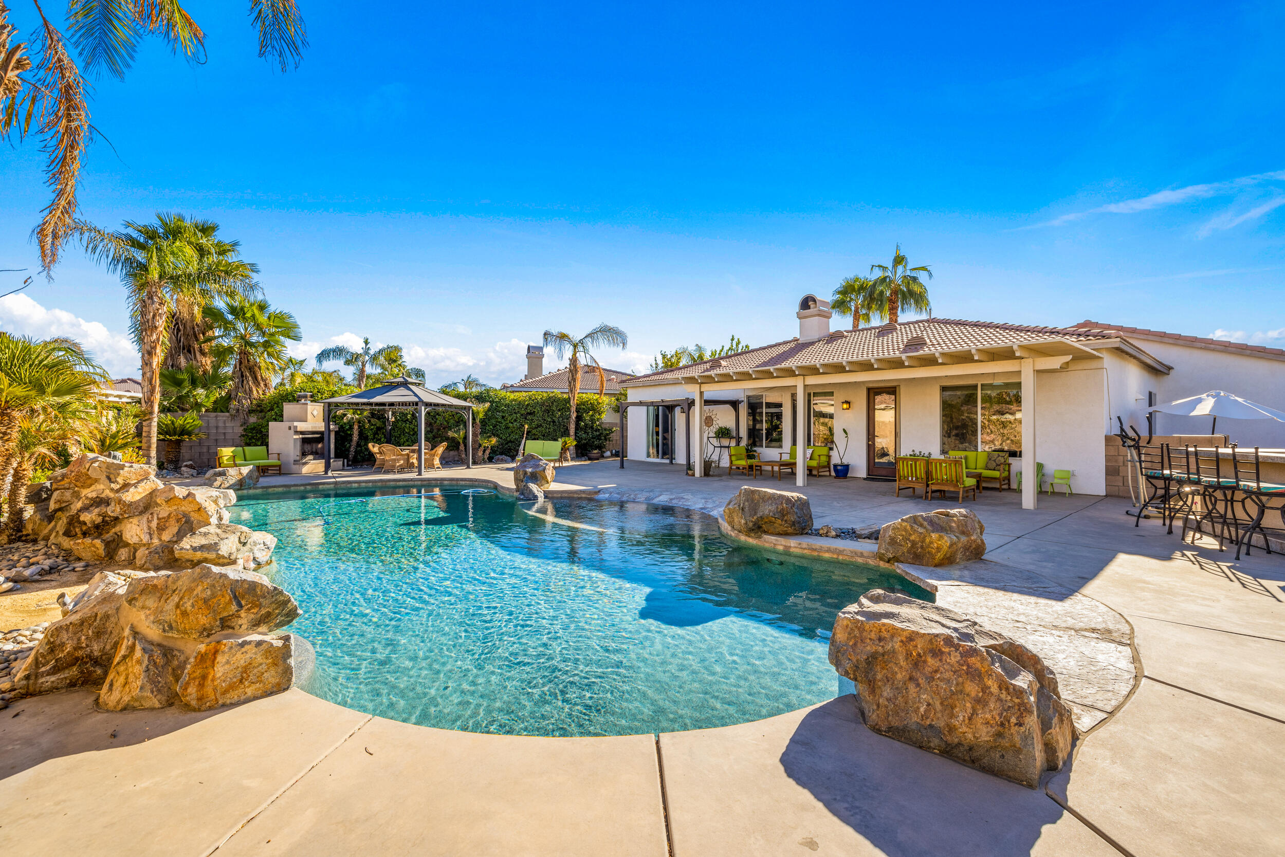 a view of a house with swimming pool and sitting area