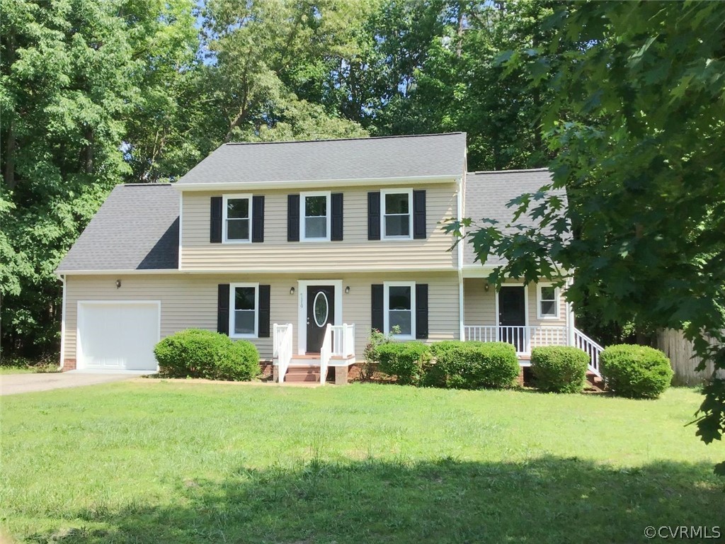 a front view of a house with a yard and trees