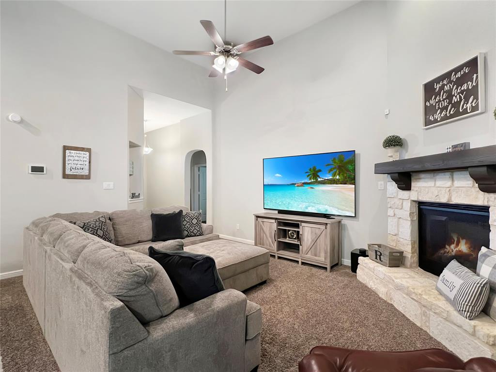 a living room with furniture a fireplace and a flat screen tv