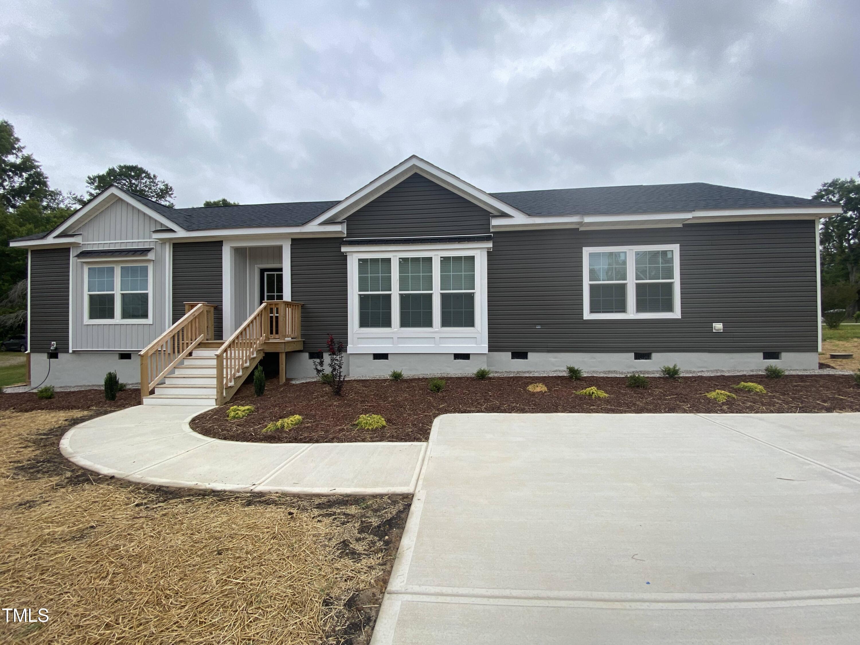 a front view of house with yard and trees around