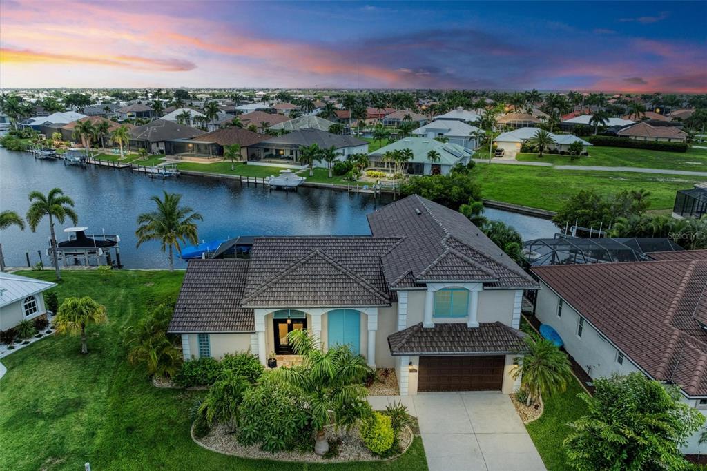 an aerial view of a house with a garden and lake view