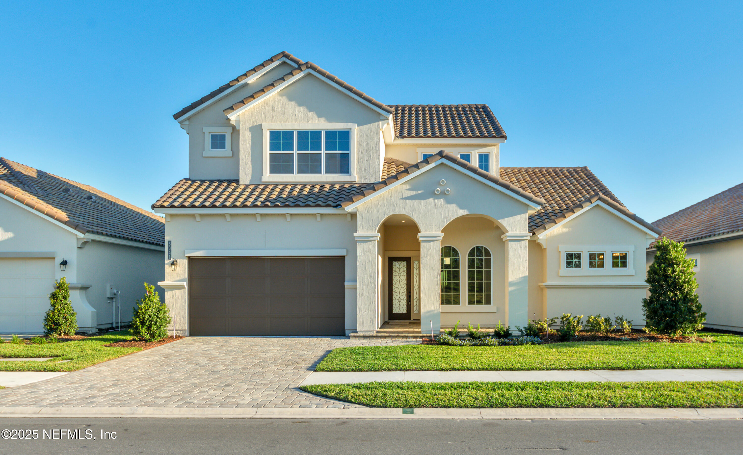 a front view of a house with a garden and yard