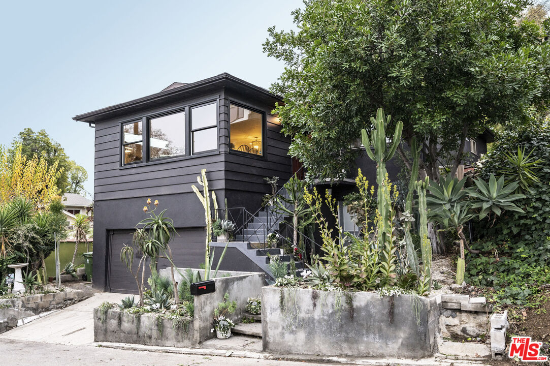 a backyard of a house with plants and outdoor seating