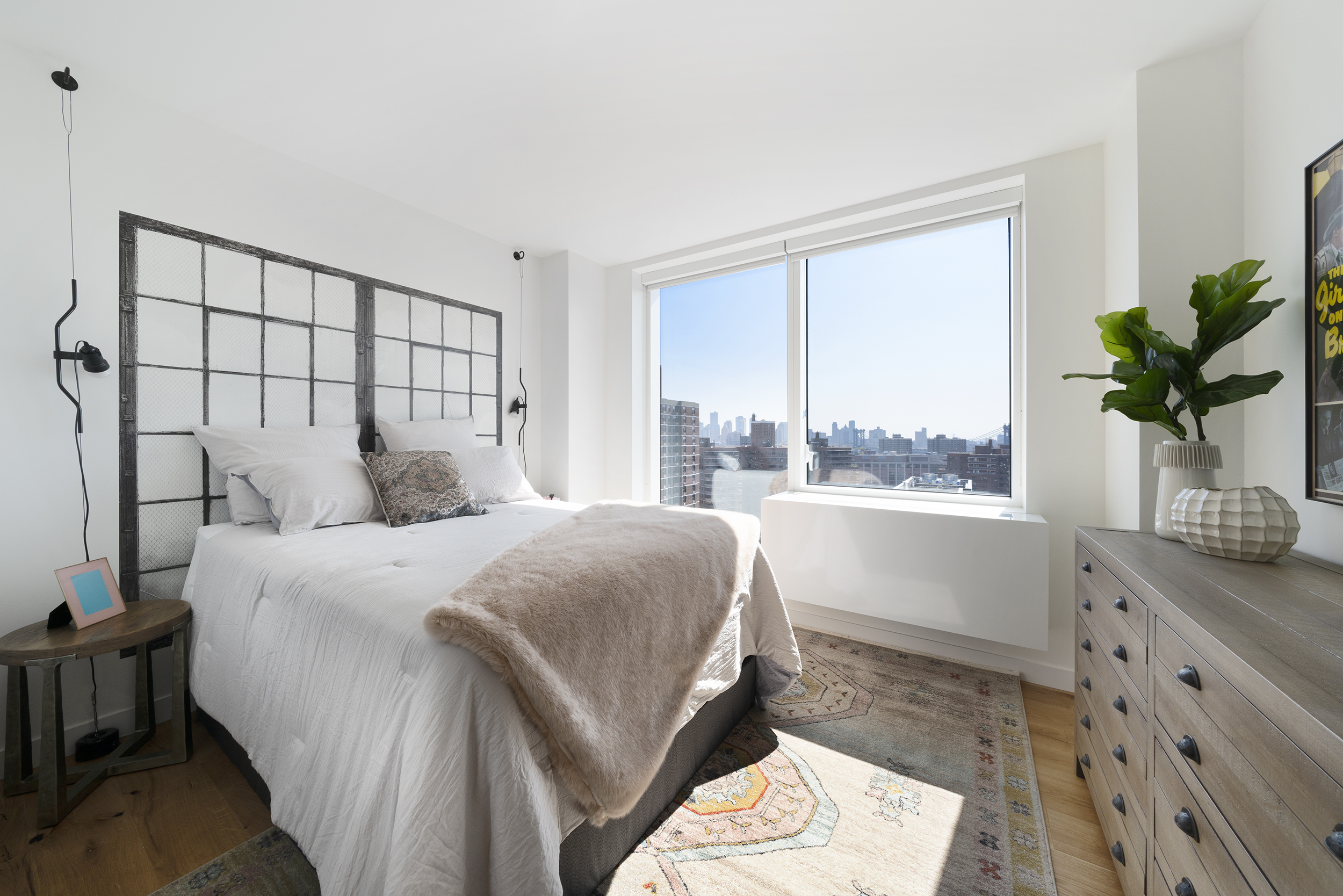 a bedroom with a large bed and a potted plant